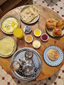 a wooden table with plates of food on it at Riad Dar Yamna Marrakech in Marrakesh +39 photos