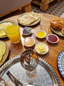 a wooden table with plates of food and drinks on it at Riad Dar Yamna Marrakech in Marrakesh