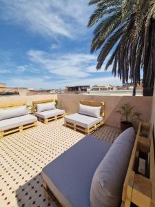 two beds on a patio with a view of the beach at Riad Dar Yamna Marrakech in Marrakesh