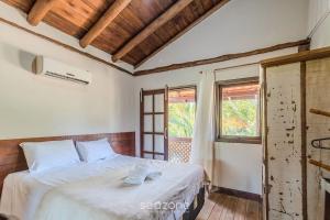 a bedroom with a bed with two towels on it at Beautiful Pousada in the middle of nature in Bombinhas in Canto Grande +126 photos