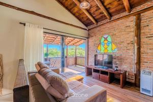 a living room with a couch and a television at Beautiful Pousada in the middle of nature in Bombinhas in Canto Grande