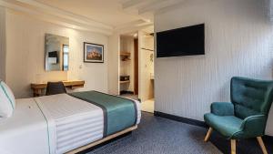 a hotel room with a bed and a chair at Uniko Living Roma in Mexico City