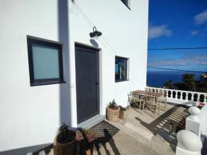 a white house with a door and a table and chairs at Nido Anaga in Santa Cruz de Tenerife +6 photos