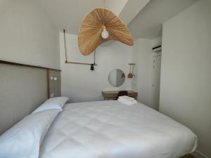 a bedroom with a large white bed with a fan at Nido Anaga in Santa Cruz de Tenerife
