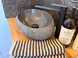 a stone sink and a bottle of wine on a counter at Whales and Bales in Bremer Bay +22 photos