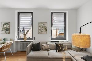 a living room with a couch and two windows at Stay COZY - The Lounge- Kingsize - Terrasse - Beste Lage in Aschaffenburg +6 photos