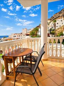 a table and chairs on a balcony with a view of the ocean at Lina Mogan in Puerto de Mogán