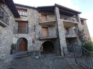 an old stone building with balconies and a door at Casa Cosculluela in Aínsa