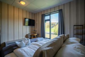 a living room with a couch and a large window at Hótel Skógafoss by EJ Hotels in Skogar