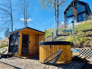 a small wooden building with a trash can next to it at Cëchô Woda in Parchowo