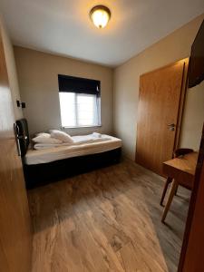 a small room with a bed and a window at Hótel Skógafoss by EJ Hotels in Skogar