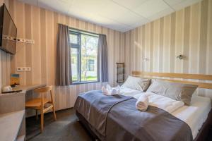a bedroom with a bed and a desk and a window at Hótel Skógafoss by EJ Hotels in Skogar +77 photos