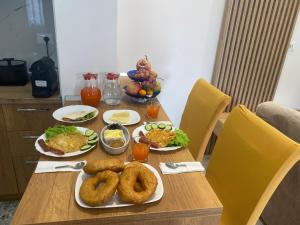 a wooden table with plates of food on it at Guest House Nuhellari 2 in Çorovodë +7 photos