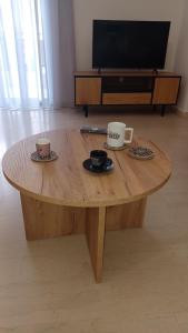 a wooden coffee table with two cups and plates on it at P&M House in Agrinio