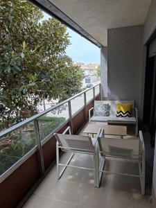 a balcony with a table and chairs and a view of the ocean at La casa en la playa in Rota