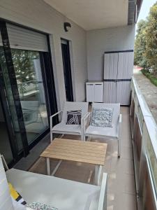 two chairs and a coffee table on a balcony at La casa en la playa in Rota