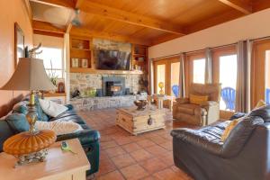 a living room with leather furniture and a stone fireplace at Golf, Lakes & Trails! Truth Or Consequences Home in Truth or Consequences