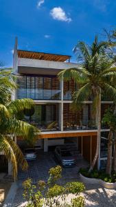 a house with palm trees in front of it at Luxury Beachfront 3BR Appartment in Tulum