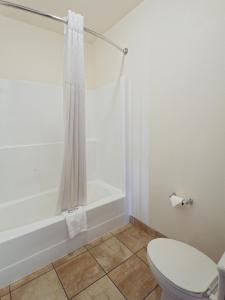 a bathroom with a toilet and a bath tub at SilverStone Inn North Spokane in Spokane