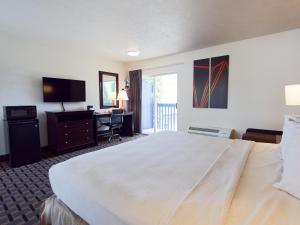 a hotel room with a large bed and a desk at SilverStone Inn North Spokane in Spokane
