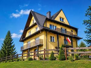 a large yellow house with a gambrel roof at SIEDLISKO HARENDA BIESZCZADY in Czarna