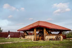 a wooden pavilion with a red roof in a field at Tylko Dobro Siedlisko na Jurze in Pabianice
