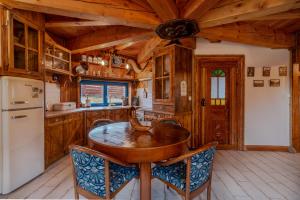 a kitchen with a wooden table and a refrigerator at Tylko Dobro Siedlisko na Jurze in Pabianice