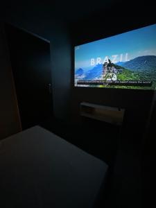a television screen in a dark room with a table at Suíte Neblina in Garanhuns
