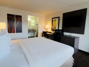 a bedroom with a large white bed and a flat screen tv at SilverStone Inn North Spokane in Spokane +19 photos