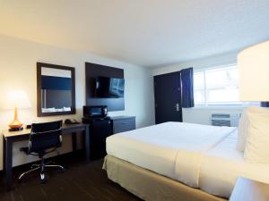 a hotel room with a bed and a desk with a computer at SilverStone Inn North Spokane in Spokane