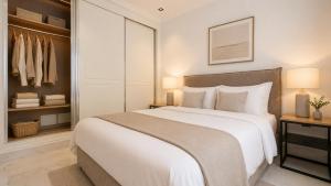 a bedroom with a large white bed and a closet at Prestige House La Marsa Terrasse Jacuzzi & Garage in La Marsa