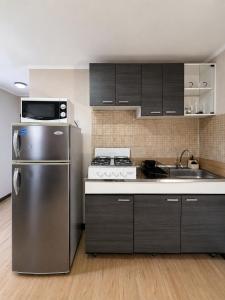 a kitchen with a stainless steel refrigerator and a sink at Valfe Apartments in Palm-Eagle Beach