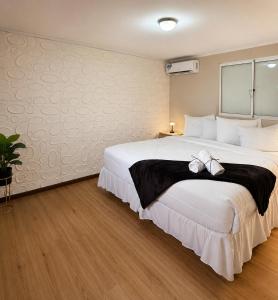 a bedroom with a large white bed with a bow on it at Valfe Apartments in Palm-Eagle Beach