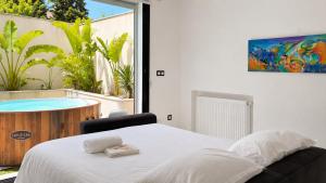 a bedroom with a bed and a tub with a painting at Prestige House La Marsa Terrasse Jacuzzi & Garage in La Marsa