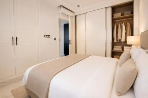 a bedroom with a white bed and a closet at Prestige House La Marsa Terrasse Jacuzzi & Garage in La Marsa