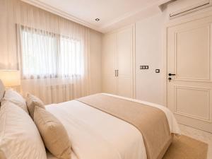 a white bedroom with a bed and a window at Prestige House La Marsa Terrasse Jacuzzi & Garage in La Marsa