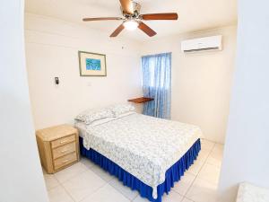 a bedroom with a bed and a ceiling fan at Kenridge Residences in Saint James