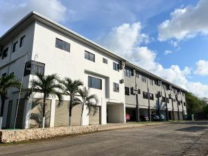 a white building with palm trees in front of it at Paradizio in Coco