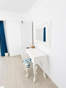a white dressing table with a mirror and a stool at Hayal Ada in Bozcaada