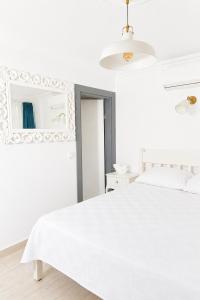 a white bedroom with a white bed and a mirror at Hayal Ada in Bozcaada