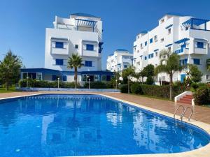 a swimming pool in front of two apartment buildings at Luxury apartment Smir Park - Marina Smir in Marina Smir