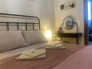 a bedroom with a bed with two towels on it at Casa de Elena Marousi in Athens