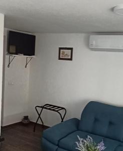 a living room with a blue couch and a tv at Dudov Hlad in Batina +15 photos
