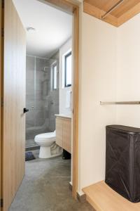 a bathroom with a toilet and a glass shower at Un escape moderno dentro de Zibatá in San Vicente Ferrer