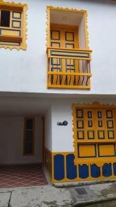 a building with yellow and blue doors and a balcony at Hostería santa María in Filandia +3 photos
