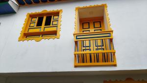 two windows and a balcony on the side of a building at Hostería santa María in Filandia