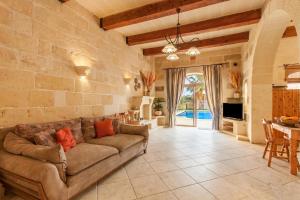 a living room with a couch and a table at Centre Island Gozitan Farmhouse & Pool - Happy Rentals in Kerċem