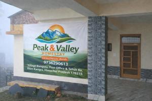 a banner on the side of a house with a sign at peak&valley homestay in Dharmsāla +1 photo