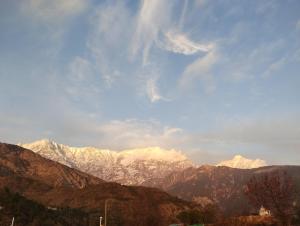 a view of a mountain range with snow covered mountains at peak&valley homestay in Dharmsāla