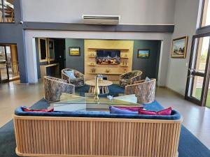 a living room with a couch and a table and chairs at TACOA Boutique Hotel in Westonaria